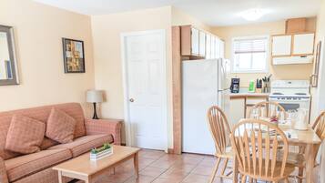 A compact living space with a kitchenette, a dining area, and a living room.