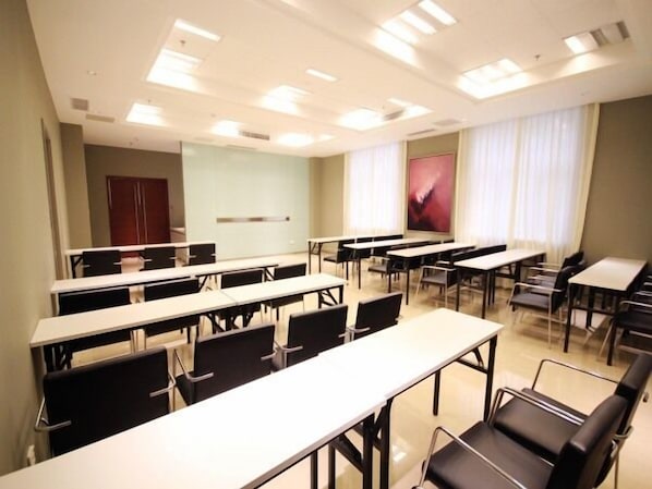 A conference room with multiple tables and chairs, a large window with curtains, and a door in the background. - Jinjiang Inn Langfang High-Speed Rail Station Yinhe South Road (Langfang)