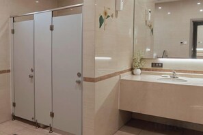 A restroom with three stalls, a sink, and a mirror. - Jinjiang Inn Langfang High-Speed Rail Station Yinhe South Road (Langfang)