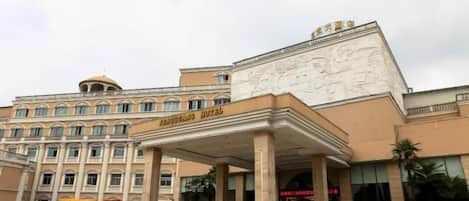 A hotel with a prominent entrance, a covered area, and a large building facade.