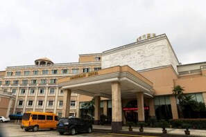 A hotel with a prominent entrance, a covered area, and a large building facade. - Fengguang Hotel (Shaoxing)
