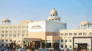 Un hotel grande con varias estructuras abovedadas, una entrada central y un estacionamiento.