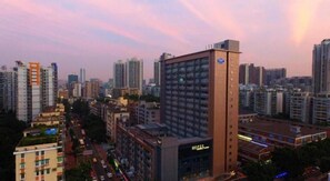 Un hotel de varios pisos, un letrero llamativo y vistas de la ciudad circundante.