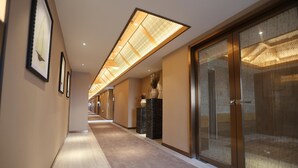 A hotel corridor with framed artwork on the walls, a long hallway with carpeted flooring, and a modern ceiling design. - Gondola Taikoo Hotel (Guangzhou)