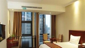 A hotel room with two beds, a desk, a chair, and a balcony with a city view. - GreenTree Inn Zhoushan Putuo Donggang Hotel (Zhoushan)