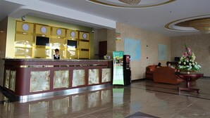 A hotel lobby with a reception desk, a chandelier, a large map on the wall, and a floral arrangement. - Greentree Inn Shanghai Baoshan Yanghang Shuichan Road Hotel (Shanghai)