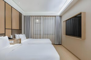 A hotel room with two beds, a desk, a phone, and a window with curtains. - Ji Hotel (Shanghai)