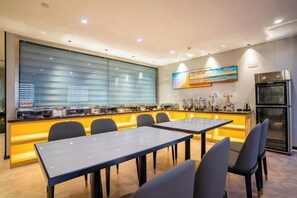 A hotel dining area with a long counter, multiple tables, and chairs. - Doukou Lijing Hotel (Nanling) (Wuhu)