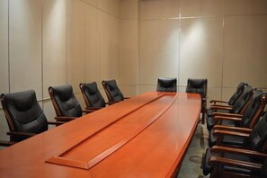 A conference room with a long wooden table and black leather chairs. - Hongyuan Hotel (Shijiazhuang)