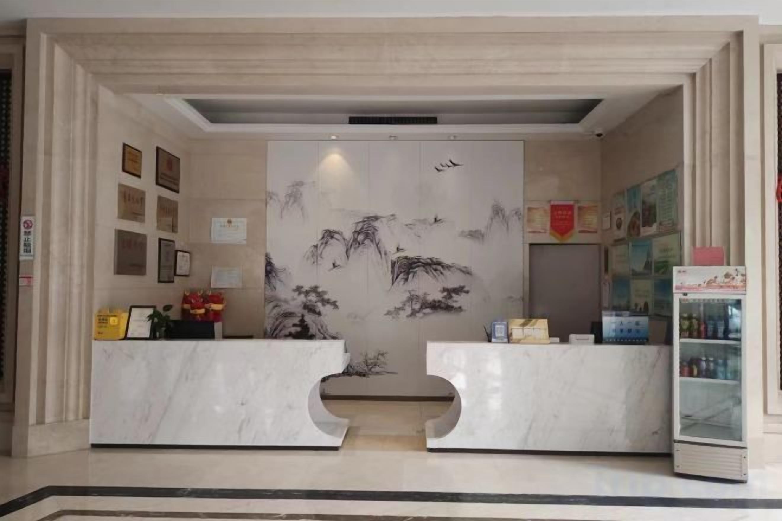 A reception area with marble counters, framed pictures on the walls, and a decorative screen with artwork.