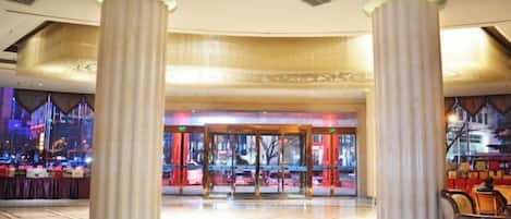 A hotel lobby with a grand entrance, large columns, and a modern design.