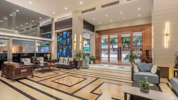 A spacious lobby with a seating area, a television, and a reception desk.