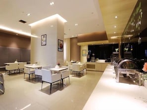 A modern hotel lobby with a long reception desk, several seating areas, and a large window. - Jinjiang Inn Lijiang Qixing Street (Lijiang)