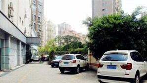 A street with parked cars and tall buildings in the background. - Jinjiang Inn Xiamen Hexiang Road West (Xiamen)