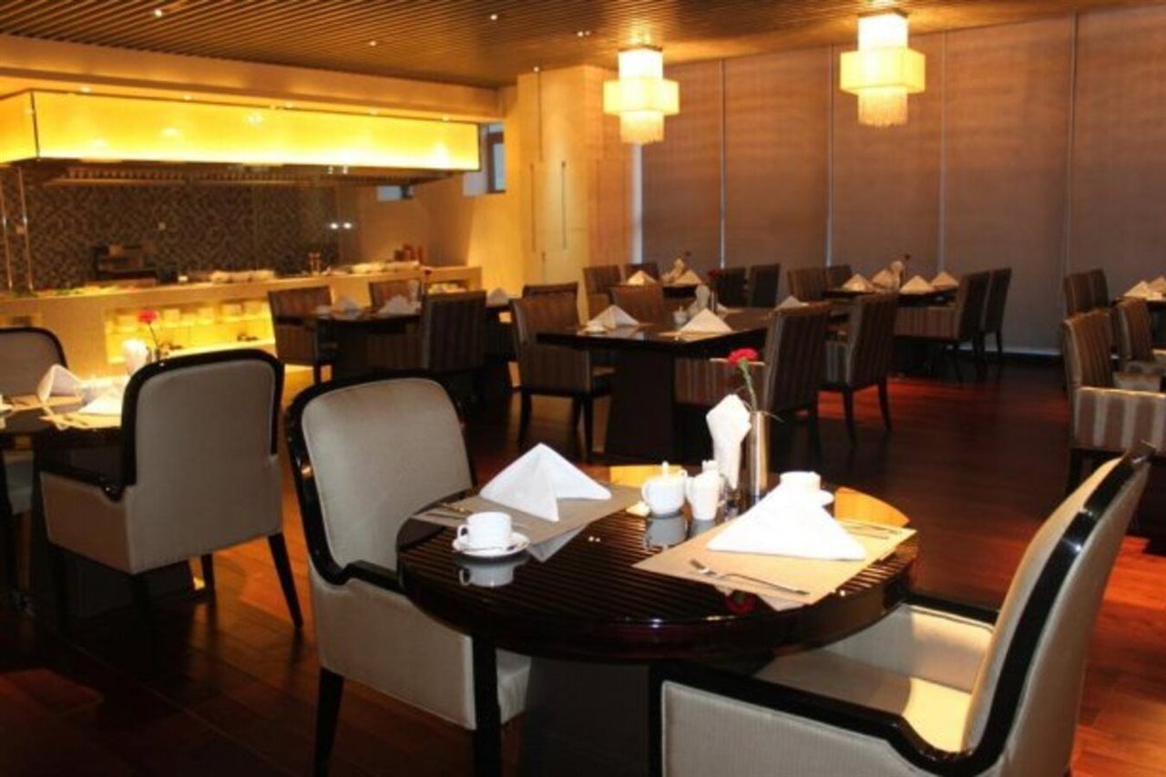A restaurant with multiple tables and chairs, some with napkins and condiments.