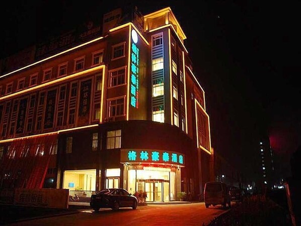 A hotel with a traditional architectural style, featuring a prominent entrance and illuminated signage. - GreenTree Inn Chuzhou Dingyuan County People's Square General Hospital Business Hotel (Chuzhou)