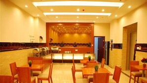 Comedor con mesas y sillas de madera, un mostrador de buffet y un mostrador de recepción.