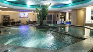 A hotel lobby with a large indoor swimming pool, a television screen, and a reception desk. - Empark Grand Hotel Fuzhou (Fuzhou)