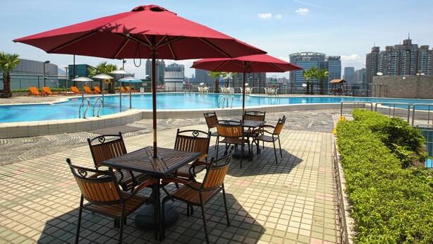 A poolside area with tables and chairs, umbrellas, and a cityscape in the background. - Empark Grand Hotel Fuzhou (Fuzhou)