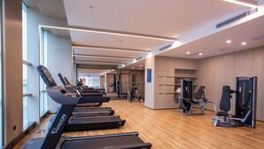A gym with treadmills, weight machines, and a wooden floor. - Empark Grand Hotel Fuzhou (Fuzhou)
