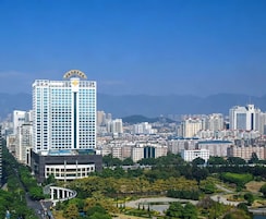 Un edificio de gran altura con vistas despejadas del paisaje urbano circundante y un parque con senderos y vegetación.