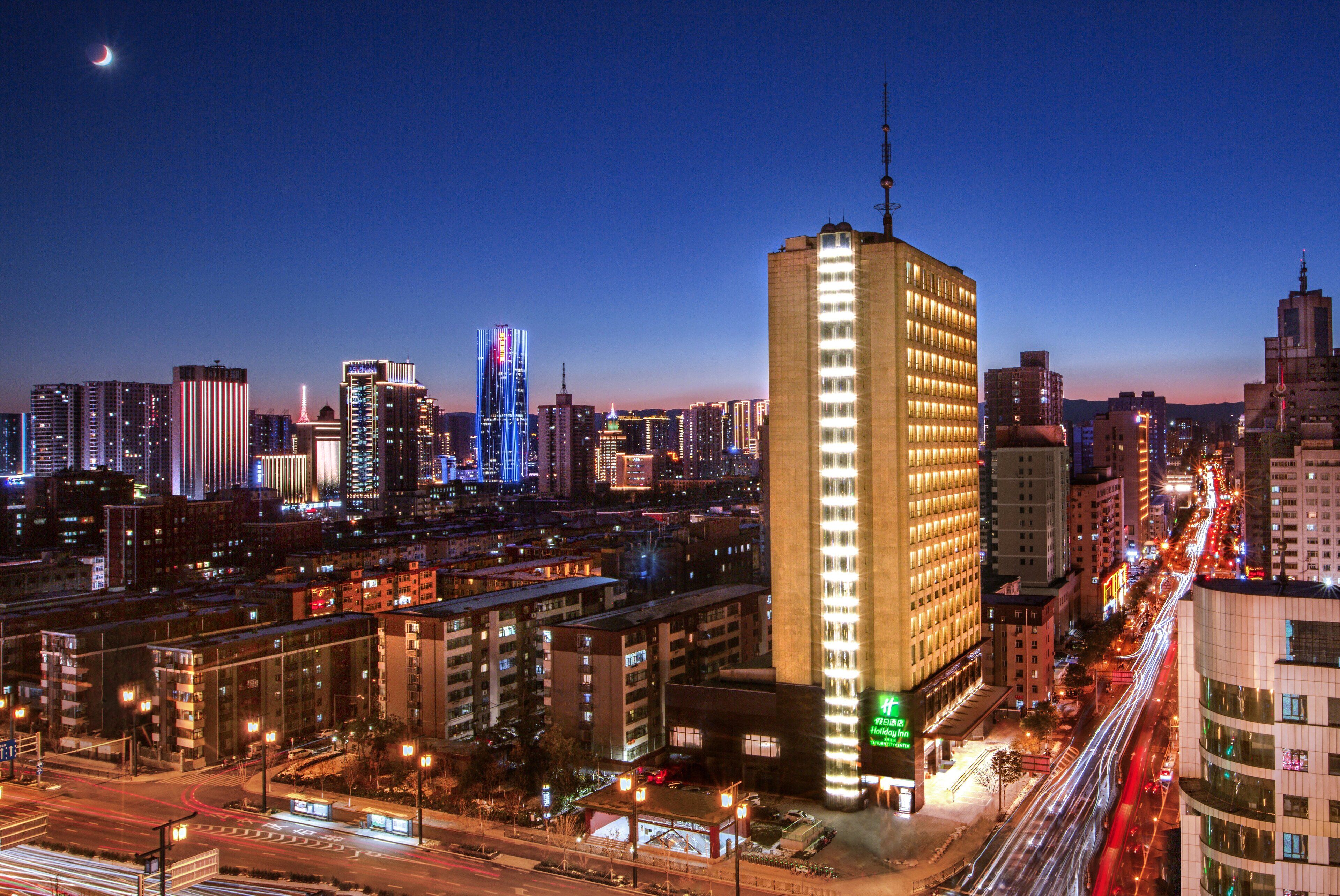 Un hôtel de grande hauteur, caractérisé par une architecture verticale imposante, de nombreux étages et une façade bien éclairée.