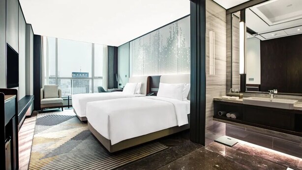 A modern hotel room with two beds, a large mirror, a vanity with a sink, and a city view. - Holiday Inn Taiyuan City Center by IHG (Taiyuan)