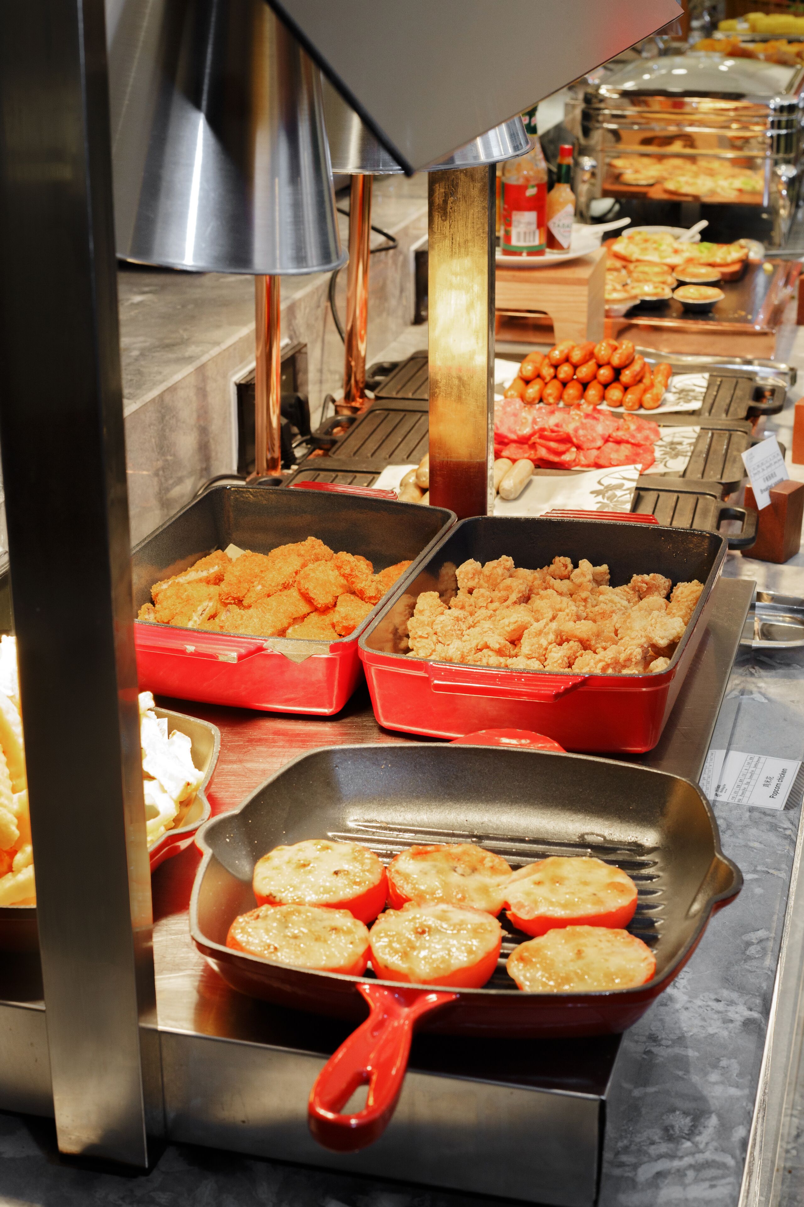 A buffet with various food items including fried chicken, baked potatoes, and other dishes.