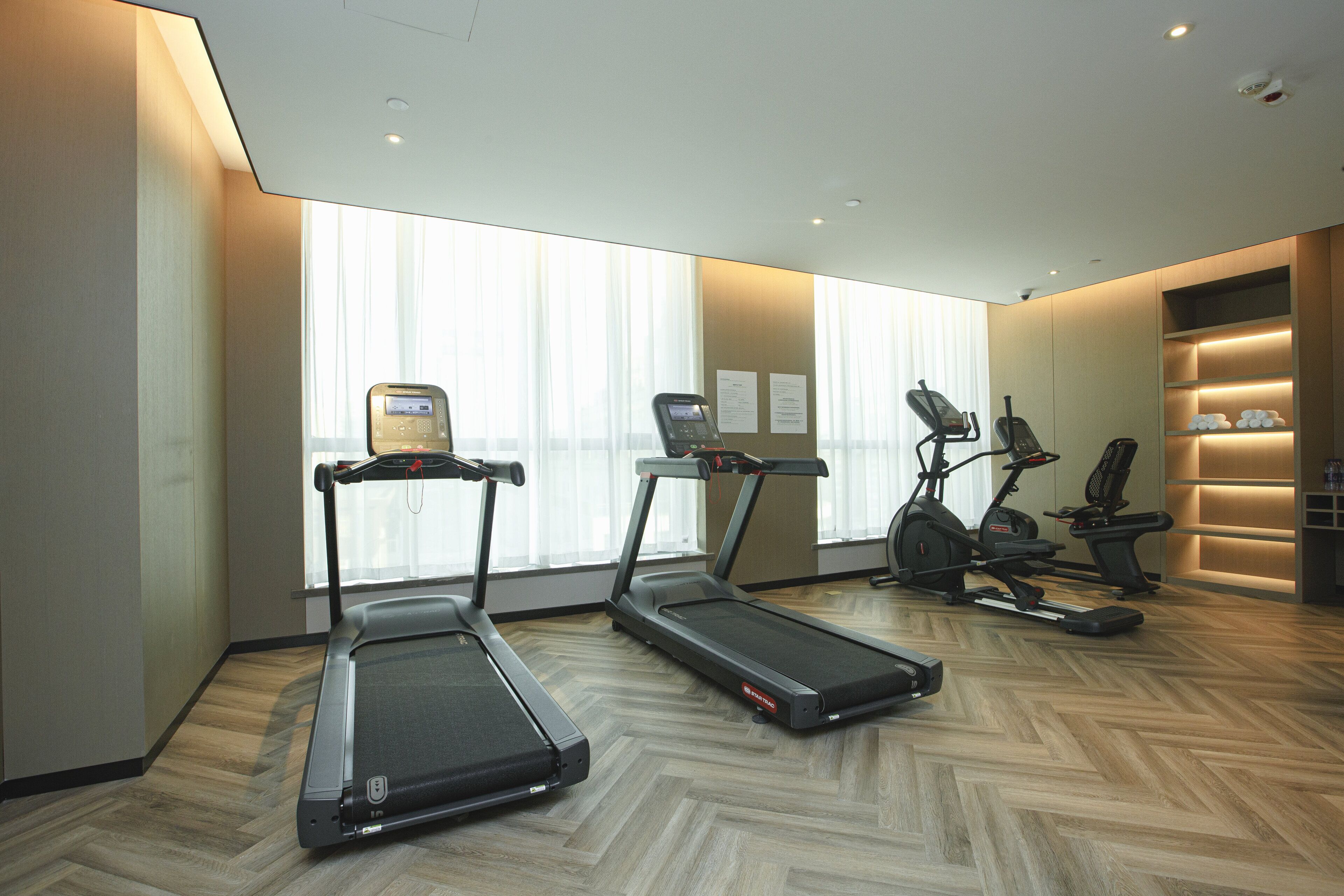 A fitness room with treadmills, an elliptical, and a stationary bike.