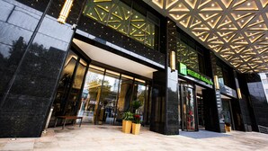 A modern hotel entrance with a geometric ceiling design, large glass windows, and a sign indicating it is a Holiday Inn. - Holiday Inn Taiyuan City Center by IHG (Taiyuan)