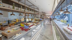 A buffet setup with various food items and serving utensils. - Holiday Inn Taiyuan City Center by IHG (Taiyuan)