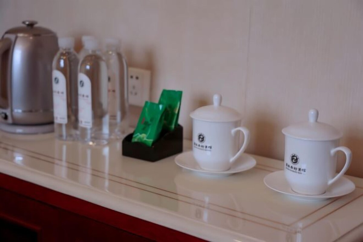 A coffee station with a coffee maker, tea bottles, and tea packets on a counter.