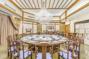 A round table with chairs, a chandelier, and a wooden ceiling. - Zhongyin Hotel (Baoding)