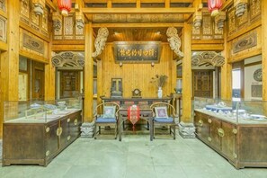 A traditional wooden interior with a reception desk, chairs, and display cases.
