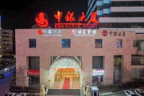 A hotel with a prominent sign, multiple windows, and a red carpet entrance. - Zhongyin Hotel (Baoding)