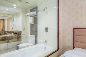 Een moderne badkamer met een bad, toilet en douche.
