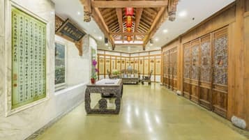 A traditional interior with a wooden ceiling, a central table, and decorative panels.