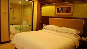 A hotel room with a large bed, a glass shower enclosure, and a painting on the wall. - Vienna Hotel Lianjiang Road - Qingyuan (Qingyuan)