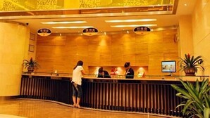 A hotel reception area with a modern design, featuring a reception desk, a large window, and a decorative chandelier. - Vienna Hotel Lianjiang Road - Qingyuan (Qingyuan)
