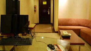 A hotel room with a desk, computer, and a couch. - Vienna Hotel Lianjiang Road - Qingyuan (Qingyuan)