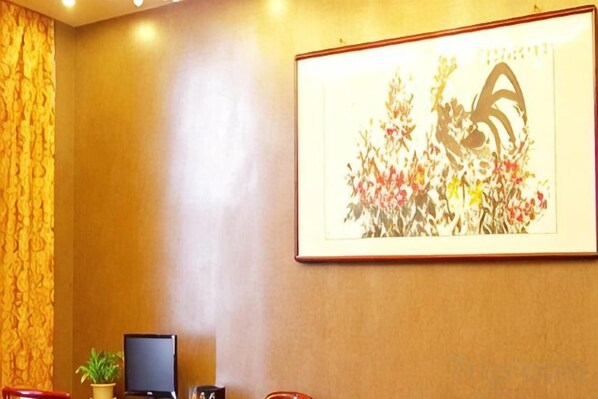 Ein gerahmtes Kunstwerk an einer Wand, ein Fernseher und ein Blumentopf in einem Zimmer.