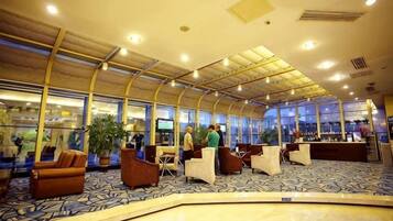 A spacious lobby with a high ceiling, seating areas, and a reception desk.