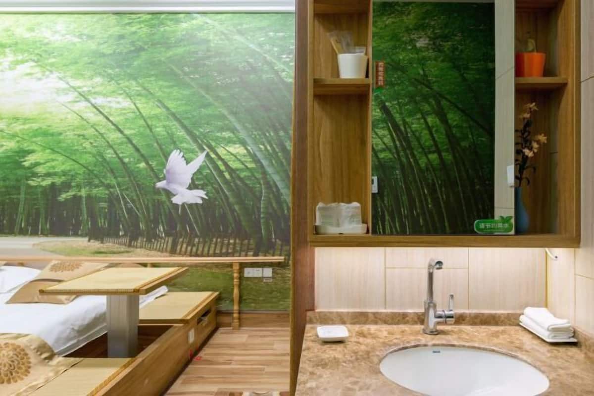 Una habitación con un ventanal amplio, una mesa de madera, un lavabo y un espejo.