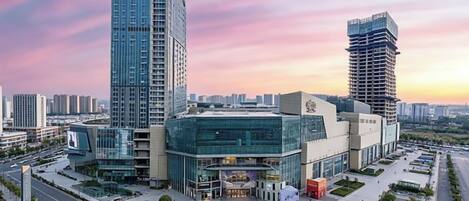 A modern building complex with multiple high-rise structures, a central plaza, and a fountain.