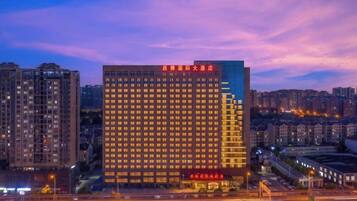 A high-rise hotel with multiple floors, a prominent entrance, and a well-lit facade.