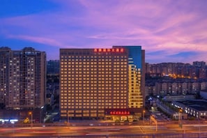 A high-rise hotel with multiple floors, a prominent entrance, and a well-lit facade. - Sylva Hotel (Changsha)
