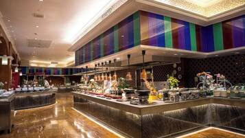 A hotel lobby with a central bar area featuring a buffet setup.