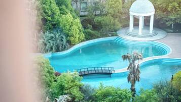A pool with a gazebo and palm trees.