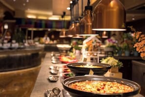 Una mesa de buffet con diferentes platos y una barra.