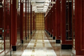 A long, narrow hallway with mirrored walls and a polished floor, leading to a large, ornate door at the end. - Sun Lake Hotel (Jiaxing)